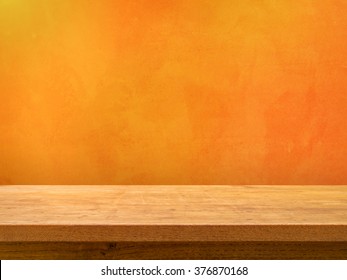 Empty Wooden Table On Orange Textured Wall