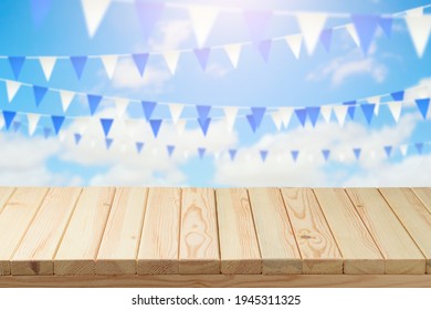 Empty Wooden Table Over Beautiful Sky With Blue And White Flags Background. Picnic Table Mock Up For Design