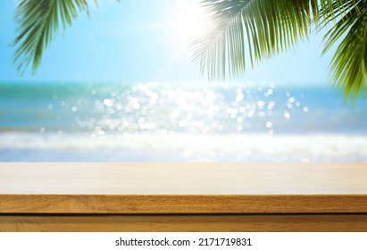 Empty wooden table over blurred sunny tropical beach background. Outdoor party mock up for design and product display. - Shutterstock ID 2171719831