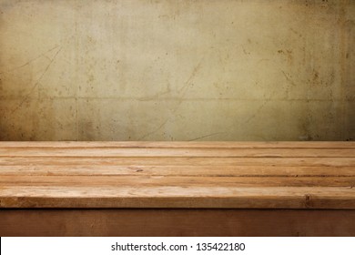 Empty wooden table over grunge concrete wall for product montage