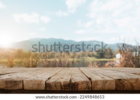 Empty wooden table are placed outdoors on beautiful spring scenery background. Nature display with beautiful sky and river.