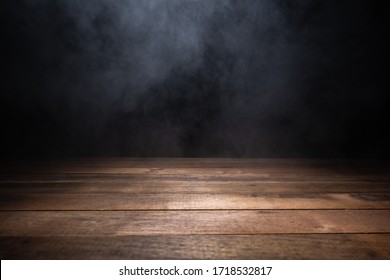 mesa vacía de madera con humo flotando sobre fondo oscuro