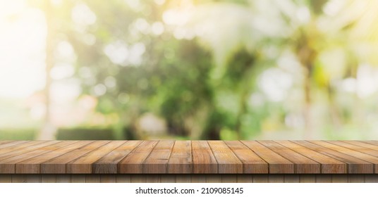 Empty wooden table top and Abstract blurred light bokeh and blur background of garden trees in sunlight. product display template with copy space.