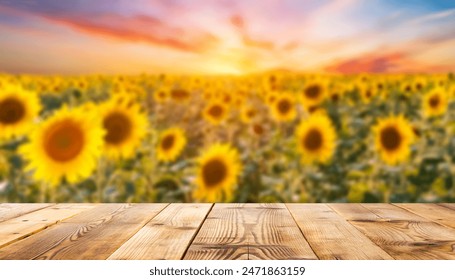 The empty wooden table top with blur background of sunflower field. Exuberant image. - Powered by Shutterstock