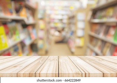 Empty Wooden Table Top With Blur Bookshelves In Bookstore Background. Can Be Used Product Display. 