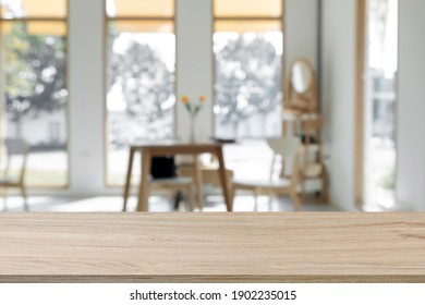 Empty wooden table top with blurred background of meeting room or coffee shop. - Shutterstock ID 1902235015