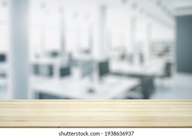 Empty wooden table top with light sunny furnished office on background, mock up
