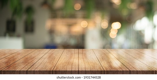Empty wooden table top with lights bokeh on blur restaurant background. - Shutterstock ID 1931744528