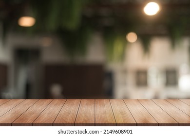 Empty wooden table top with lights bokeh on blur restaurant background. - Shutterstock ID 2149608901