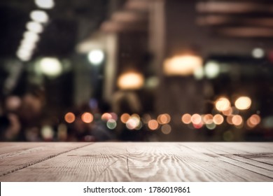 EMPTY WOODEN TABLE TOP ON DARK BOKEH LIGHTS BACKGROUND, MODERN NIGHT RESTAURANT BACKDROP FOR MONTAGE OR DISPLAY BEVERAGES, ALCOHOLIC DRINKS, COFFE CUPS, FOOD, DRINKS OR OTHER LUXURIOUS PRODUCTS - Shutterstock ID 1786019861