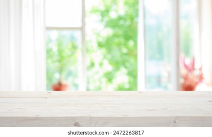 Empty wooden table top on blur curtained open window view on green summer garden background - Powered by Shutterstock