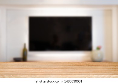 Empty Wooden Table Top With Tv In Living Room Blurred Background.