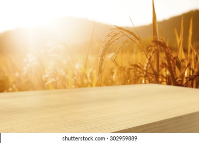 Empty  wooden table with wheat field background, product display montage