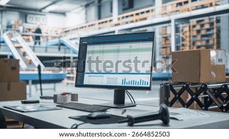 Empty Workplace Of Sorting Center Employee with Desktop Computer Monitor And Barcode Reader. Conveyor Belt With Online Orders Packaged In Cardboard Boxes Working in the Background