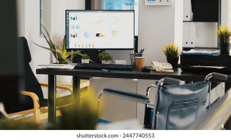 Empty workplace used for bookkeeping, forecasting, and financial analysis purposes. Company workspace with nobody in and marketing pie charts on computer monitors left open, panning shot