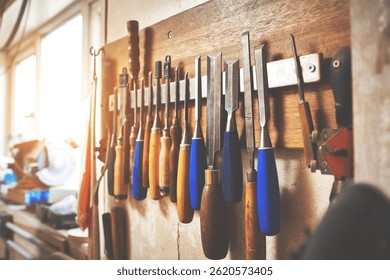 Empty workshop with DIY tools and equipment. Set of screw drivers and carpenter files hanging in the garage. Repair shop and woodwork hardware for crafting, building or repairing wooden furniture