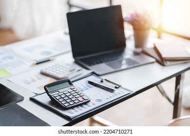 Empty Workspace, No People, Office Desk, With Laptop, Calculator, Graphs, Documents On The Table.