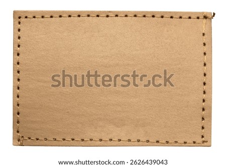 Empty worn leather patch on blue jeans on a white background. Empty space for writing. Blank leather jeans label
