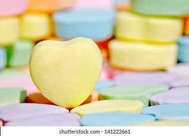 Empty yellow heart candy over colorful bonbon