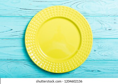 Empty yellow plate on wooden table . Top view background