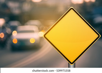 Empty yellow traffic sign on blur traffic road with colorful bokeh light abstract background. Copy space of transportation and travel concept. Retro tone filter effect color style.