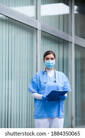 EMS UK Paramedic Woman Wearing Personal Protective Equipment PPE Holding Clipboard,standing In Front Of ICU Hospital PCR Testing Site,COVID-19 Pandemic Outbreak Crisis,worried Exhausted Staff Portrait