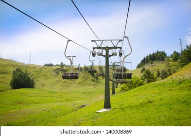 Emtpy Chairlift In Ski Resort. Shot In Summer With Green Grass And No Snow