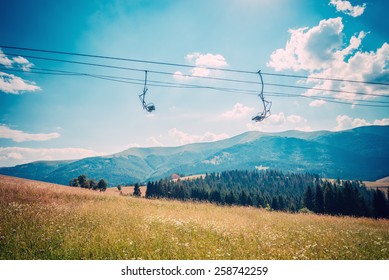 Emtpy Chairlift In Ski Resort In Summer With Green Grass And No Snow