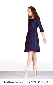 En pointe walking left looking down blue tartan dress clipping for careful walking, crossing roads, tiptoe or walking a tightrope with balance Young female dancer tartan dress pink satin pointe shoes