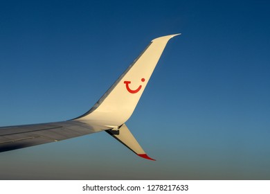 EN ROUTE BIRMINGHAM TO VERONA - SEPTEMBER 2018: Curved Wing Tip Of A TUI Holiday Jet Against A Deep Blue Sky.