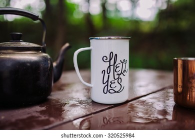 Enamel Mug With A Hell Yes Sign On It In The Outdoors Setting