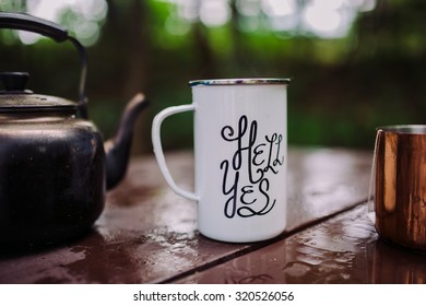 Enamel Mug With A Hell Yes Sign On It In The Outdoors Setting