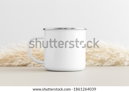 Enamel mug mockup with a pampas on a beige table.