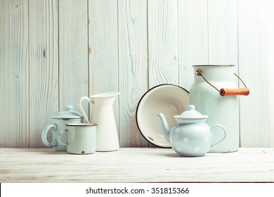 Enamelware on the kitchen table over blue wooden wall