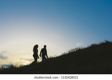 Enamored Couple Embraced At Sunset In A Backlit Photo