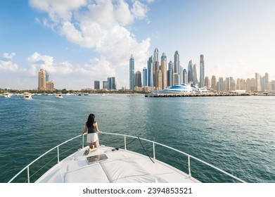 Enchanting beauty of Dubai Marina as a stylish woman embraces the tranquil sunset during a luxurious yacht ride. Sophistication and relaxation against the iconic Dubai cityscape in the United Arab Emi - Powered by Shutterstock