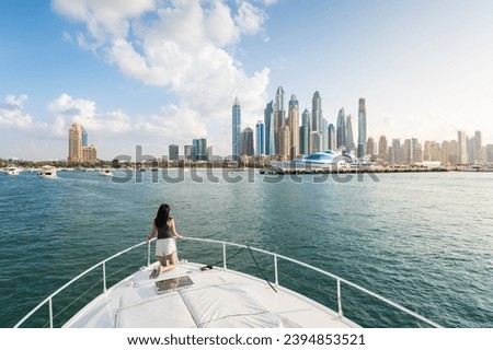 Enchanting beauty of Dubai Marina as a stylish woman embraces the tranquil sunset during a luxurious yacht ride. Sophistication and relaxation against the iconic Dubai cityscape in the United Arab Emi