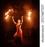 An enchanting fire dancer beautifully showcases her talent with mesmerizing flames during a performance.