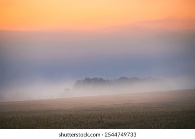 Enchanting Misty Morning Landscape with Vibrant Colors Over Meadow and Fields Beyond the Village - Powered by Shutterstock