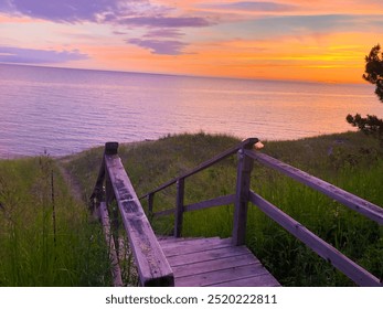 Enchanting Sunset Over West Michigan Lakeshore: Wooden Staircase Leading Down a Sandy Path and Calm Waters - Powered by Shutterstock