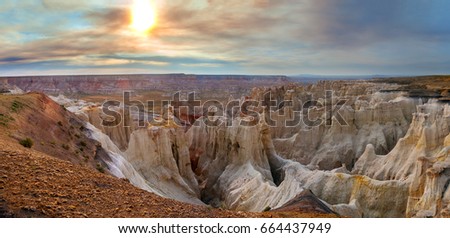 Enchanting view of Coalmine Canyon near Tuba City, Arizona.  It is late in the day and there was a nearby fire causing the sky to be filtered by colorful smoke.