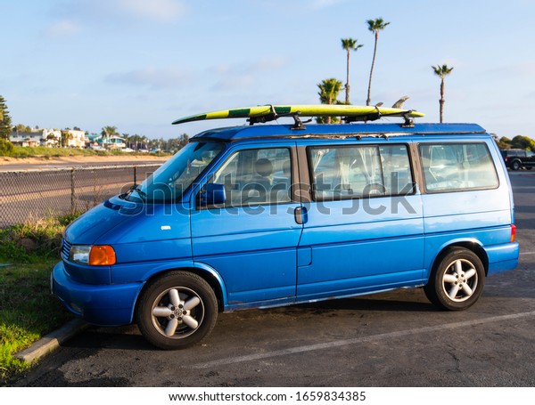 ENCINITAS, CALIFORNIA / USA - FEBRUARY 18, 2020:\
Surfer van with surf board on top during sunset at a California\
Beach. Surfing background concept in\
Cali