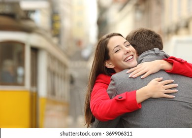 Encounter of a happy couple hugging in love in the street after a tram travel in a colorful scenery - Powered by Shutterstock