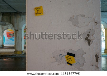Encouraging sticky notes left on underpass pylons. Text: 