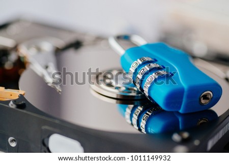 Encrypted hard disk. Padlock with cipher on an opened hard disk. Data loss