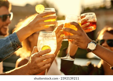 In the end, all that matters is happiness. Cropped shot of a group of unrecognizable friends having a drink and spending the day outside on a rooftop. - Powered by Shutterstock