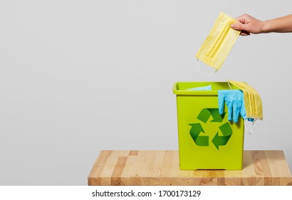 End Of Coronavirus Quarantine. A Female Hand Throws Used Face Masks Into A Trash Can. Return To Normal Life