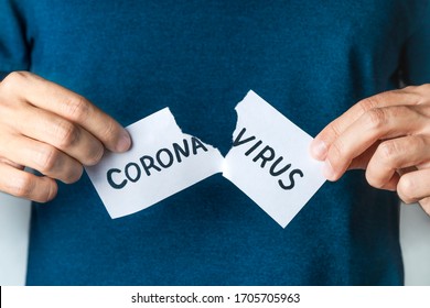 End of Covid-19 pandemic. Man tearing card with word coronavirus. Victory in fight against Pandemic. Cure corona virus.