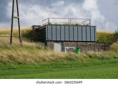 At The End Of The Meadow Is A Small Factory Building