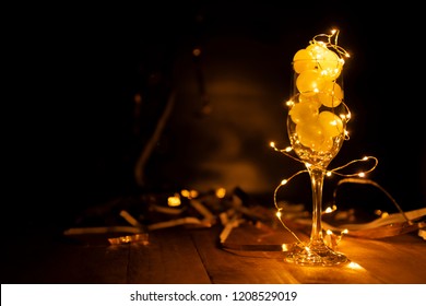 End Of The Year Concept. Glass Of Champagne With Grapes Inside, With Holiday Decoration